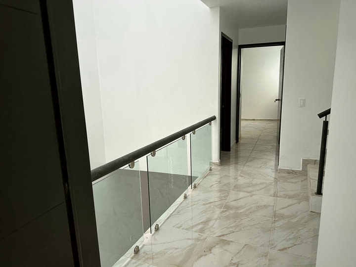 Pasillo con barandal de cristal, casa 1.